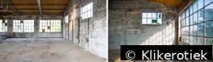 Grote lege industriële ruimte met bakstenen muren en hoge ramen.